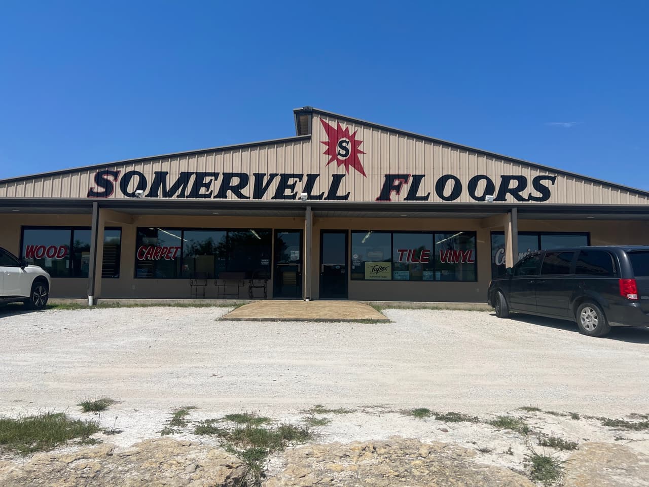 Somervell Floors flooring showroom storefront with wood, carpet, tile, and vinyl signage on Highway 144 in Granbury, TX