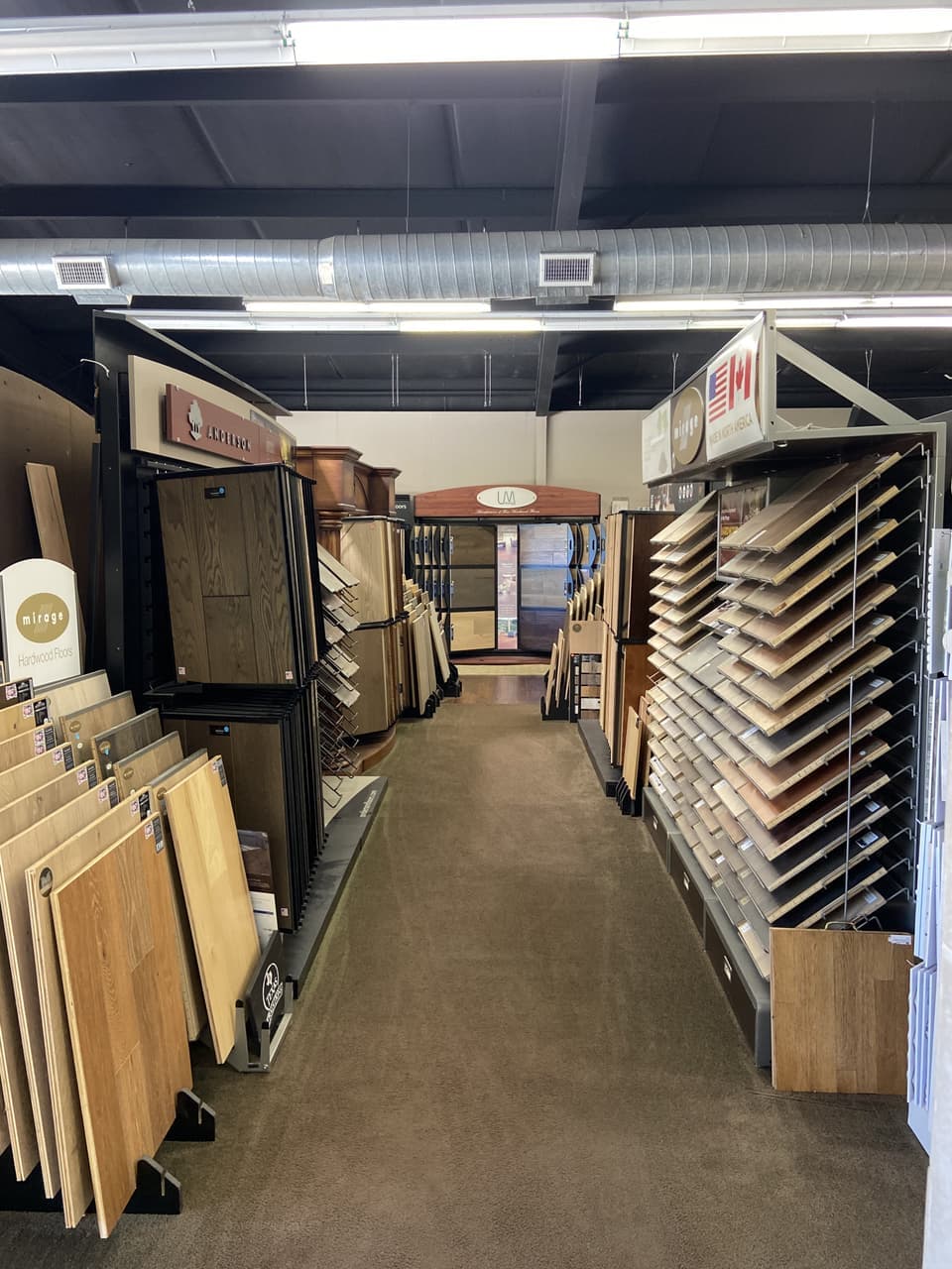 Mirage and Anderson hardwood flooring display racks in the Somervell Floors showroom aisle
